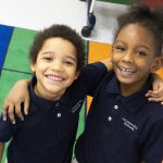 Two Kindergarten students with arms around each other. Why choose Regen? It is the best elementary school in Chicago and Cincinnati