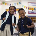 Two students with backpacks on in a classroom at the Regeneration Schools in Cincinnati and Chicago - a charter school which is an affordable private school type setting